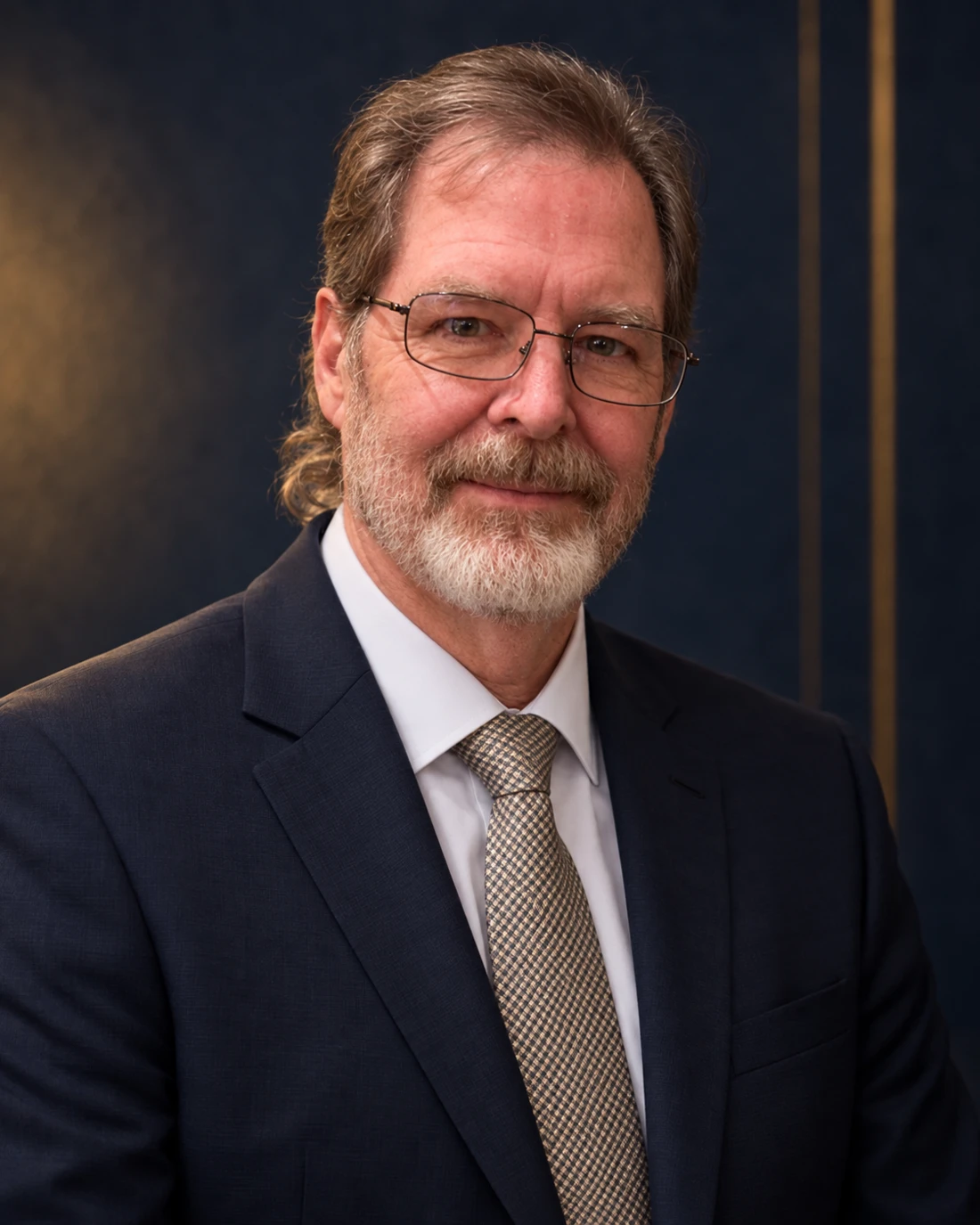 Stephen Hawkins wearing glasses, a navy suit, white shirt, and gold-toned tie